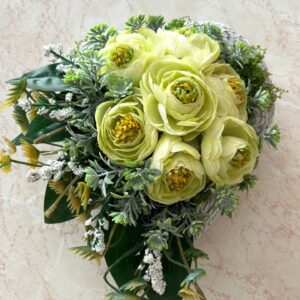 Szív alakú kőkaspóba készült sírdísz, krémszínű virágokkal, zöldekkel díszítve