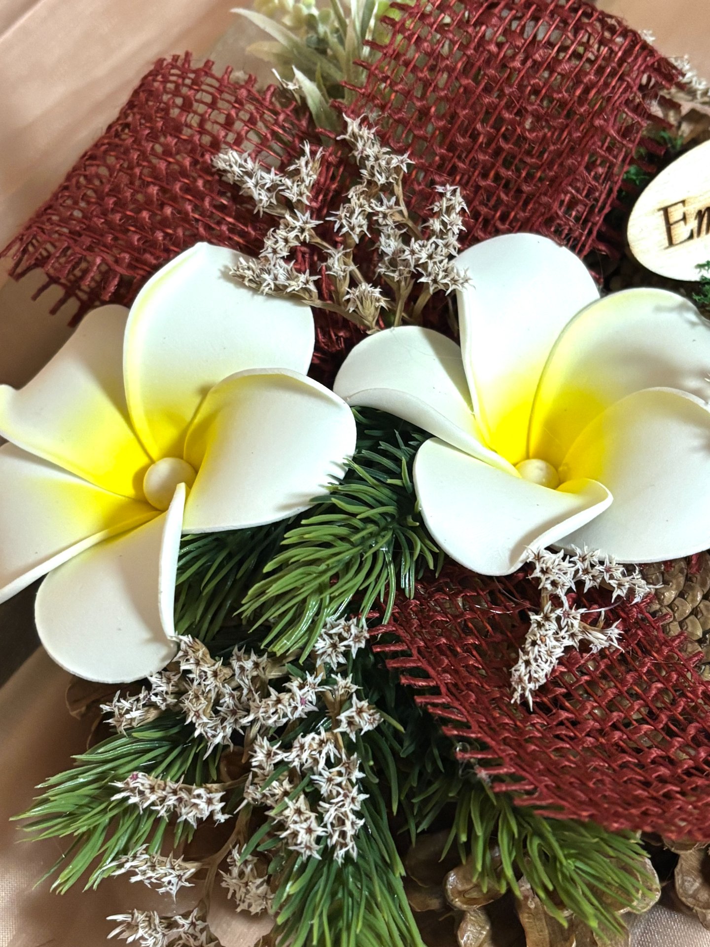 Sírdísz lakkozott toboz koszorú alapon, prémium virágfejekkel, fenyő ágacskákkal díszítve